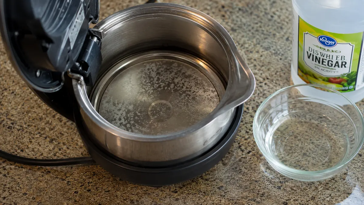 Close-up of mineral scale buildup inside an electric kettle's heating element before a descaling session