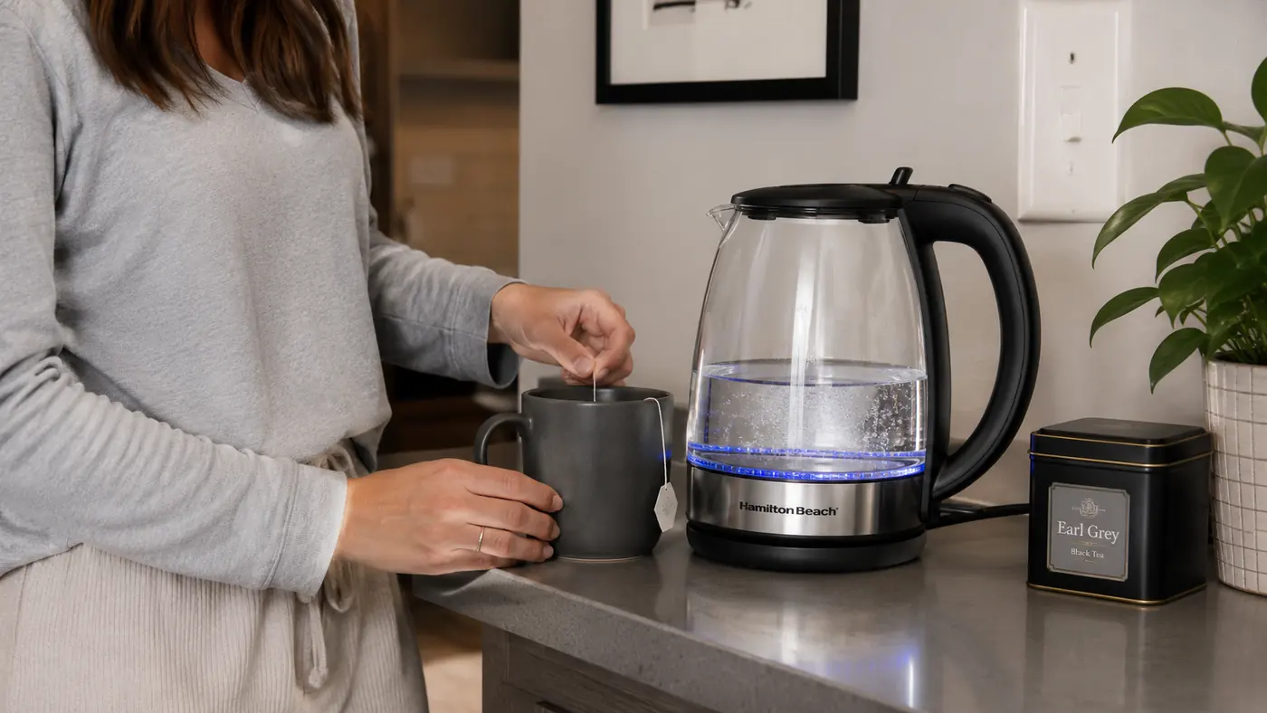 Hamilton Beach 1 Liter Electric Kettle sitting on a narrow apartment counter next to a mug and a small tea tin